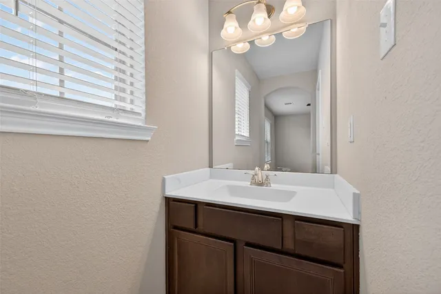 a bathroom with a sink a light fixture and a mirror