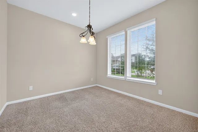 en empty room with windows and ceiling fan