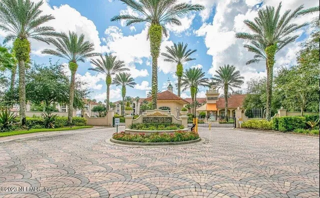 a front view of multi story residential apartment building with yard and green space