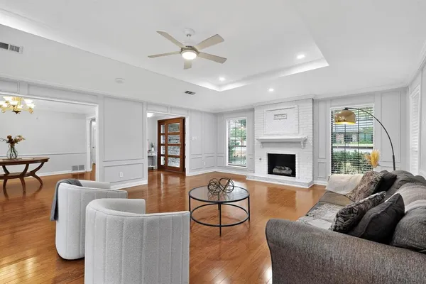 a living room with furniture a fireplace and a large window
