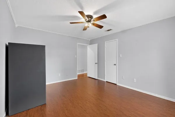 a view of an empty room with wooden floor