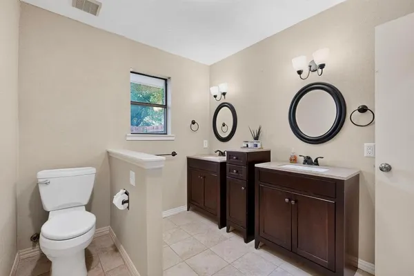 a bathroom with a toilet a sink and a mirror