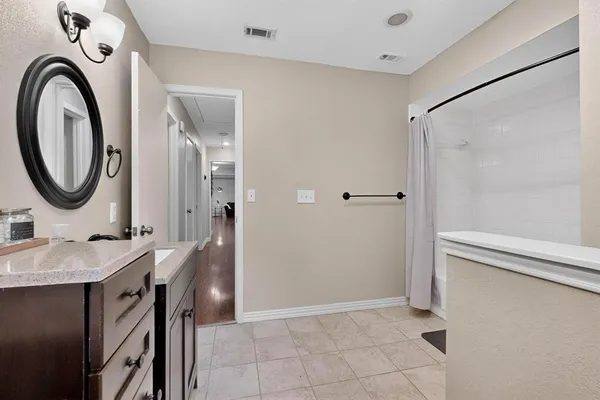 a bathroom with a granite countertop sink a mirror and a shower