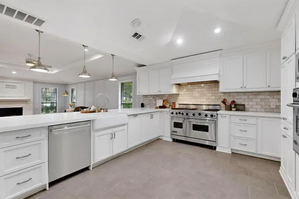 a kitchen with white cabinets and white appliances