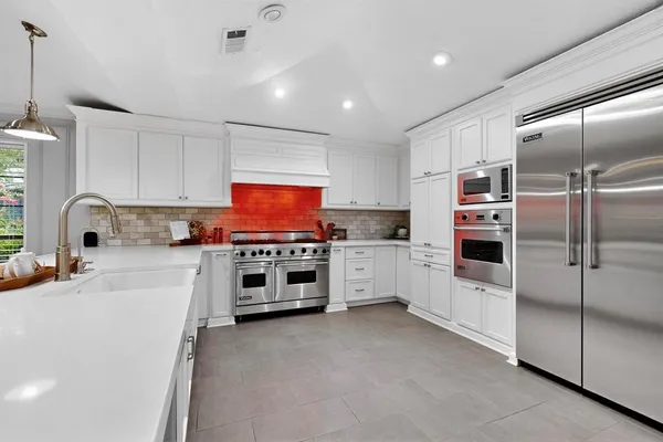 a kitchen with stainless steel appliances a refrigerator sink and cabinets