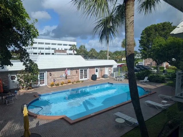 a view of a house with pool and a yard