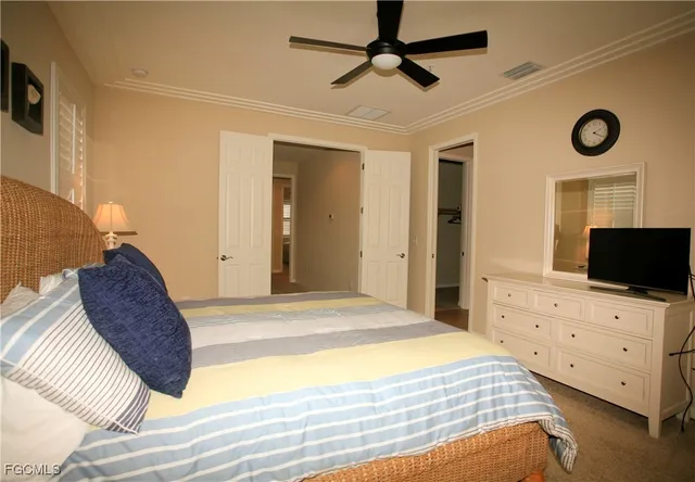 a bedroom with a bed and a flat tv screen on dresser