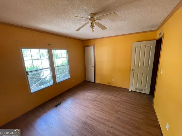 a view of empty room with wooden floor