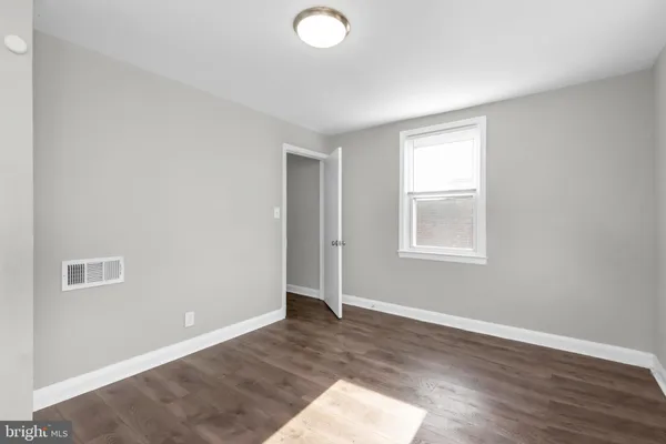 a view of a hallway with wooden floor and closet