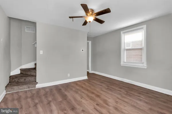 an empty room with a window and ceiling fan