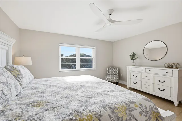 a bedroom with a bed a dresser and a window