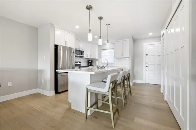 a kitchen with kitchen island a refrigerator a counter top space appliances and cabinets