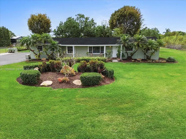a view of a house with potted plants and a table and chair