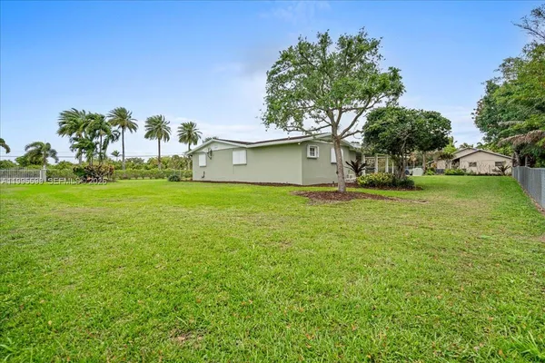 a kitchen with stainless steel appliances granite countertop a table chairs in it and wooden floors