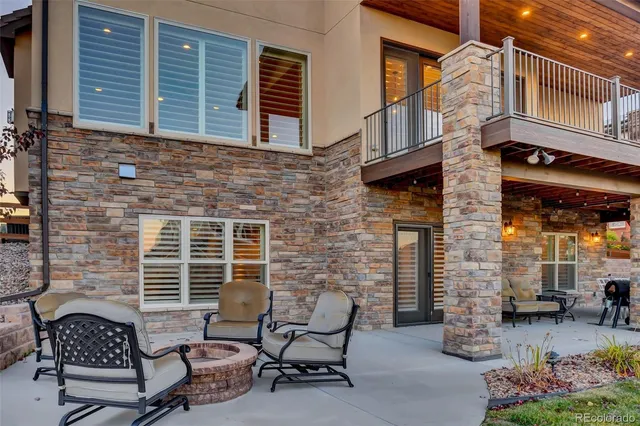 a view of a swimming pool and lounge chairs in back of the house