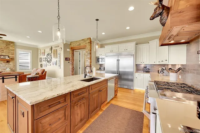a kitchen with stainless steel appliances granite countertop a sink stove and refrigerator