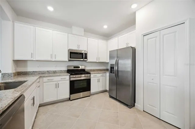 a kitchen with stainless steel appliances granite countertop a refrigerator stove a sink and dishwasher