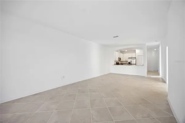 a view of a big room with wooden floor and a kitchen