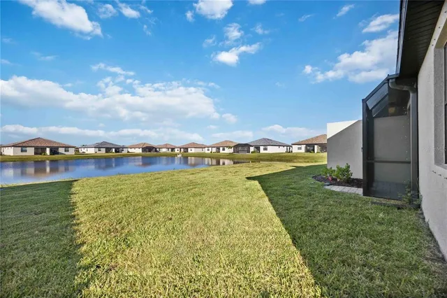 a front view of house with yard and trees in the background