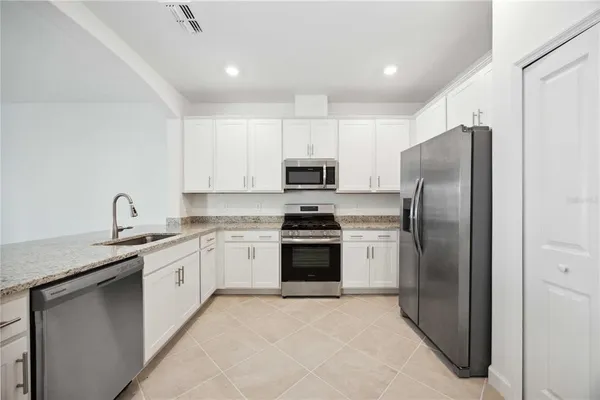 a kitchen with stainless steel appliances granite countertop a refrigerator sink and stove