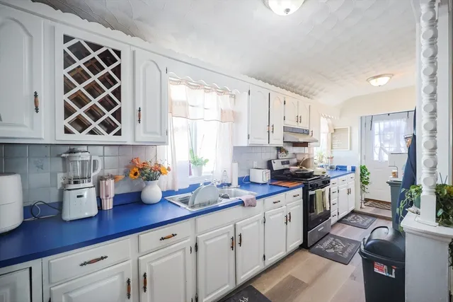a kitchen with stainless steel appliances a sink dishwasher stove refrigerator and cabinets
