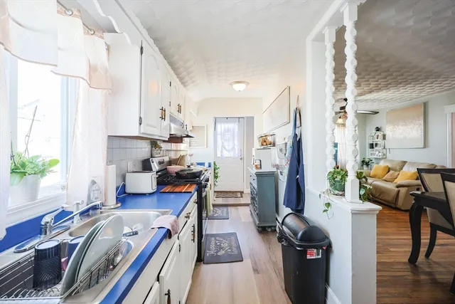 a view of a kitchen with furniture and wooden floor