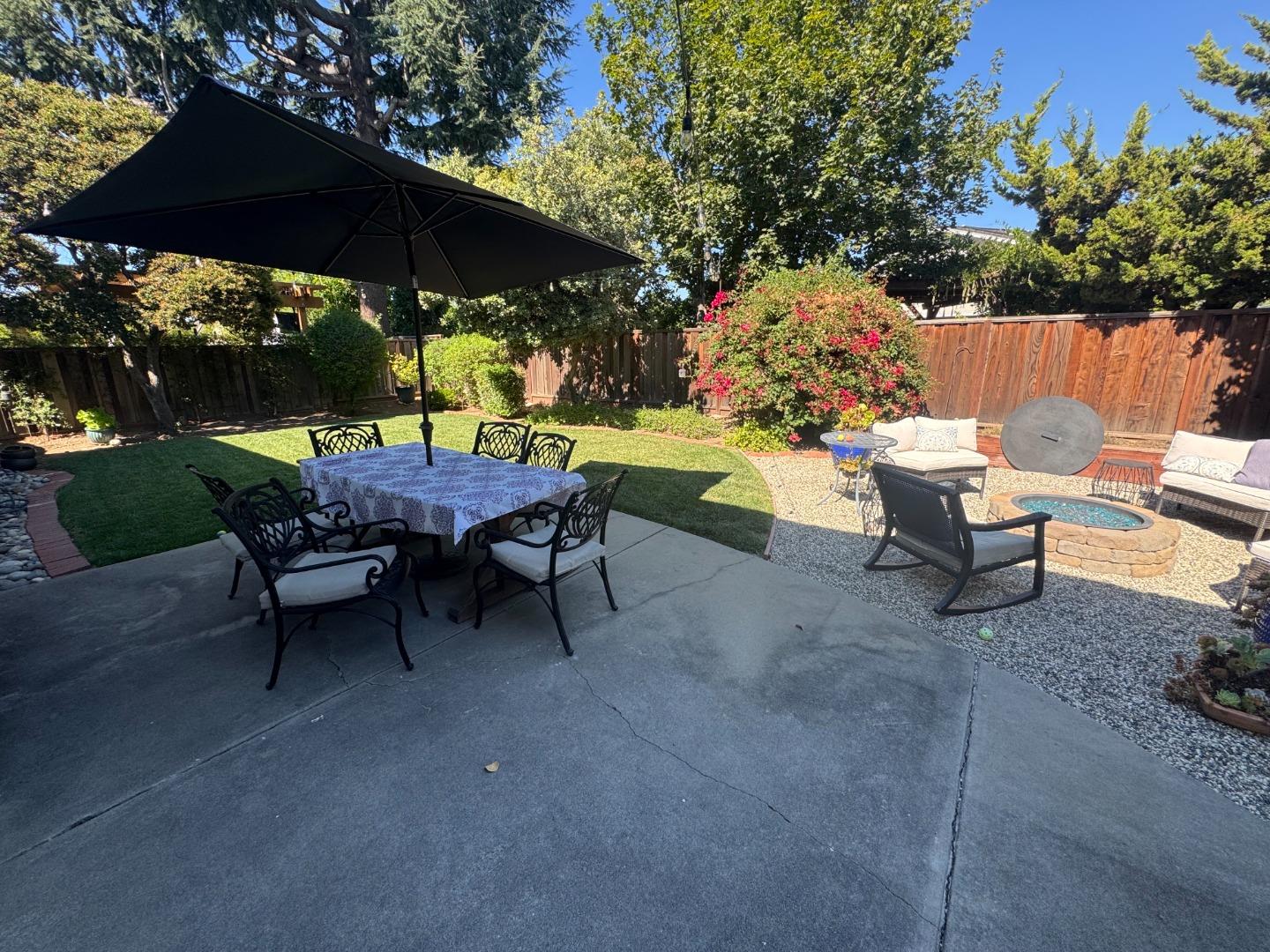 4460 Lahaina Way San Jose, CA 95118 - Photo 4 of 4 a backyard of a house with table and chairs under an umbrella