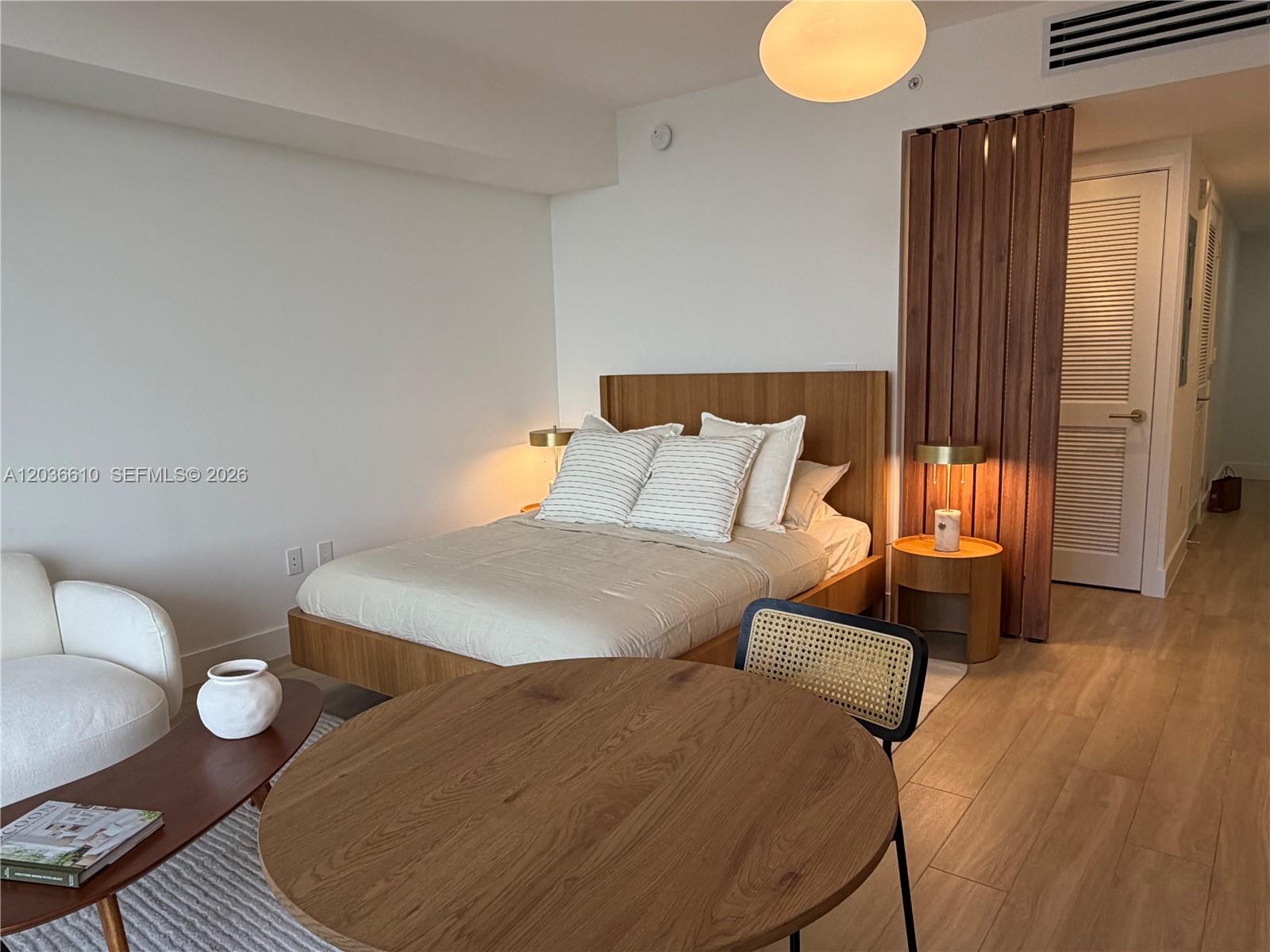 90 Northeast 32nd Street, Unit 1014 Miami, FL 33127 - Photo 5 of 39 a bedroom with a bed and wooden floor