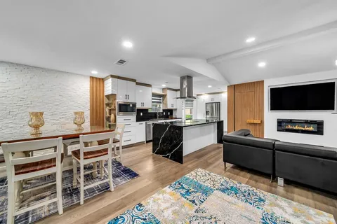 a kitchen with stainless steel appliances kitchen island granite countertop a refrigerator and a stove top oven