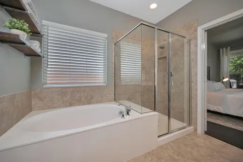 a bathroom with a tub sink and mirror