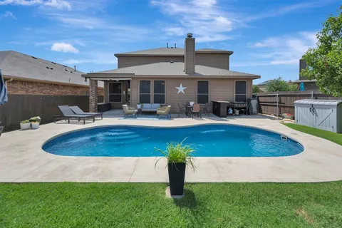 a view of a house with backyard swimming pool and sitting area