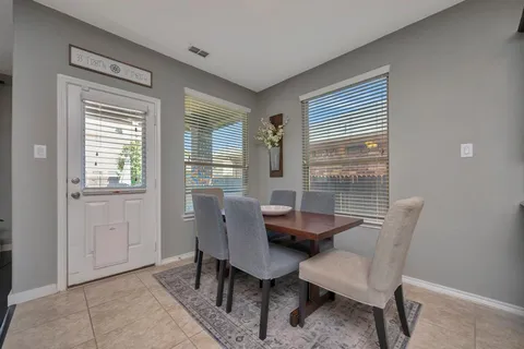 a kitchen with kitchen island granite countertop wooden cabinets a stove a microwave a island with a dining table and chairs