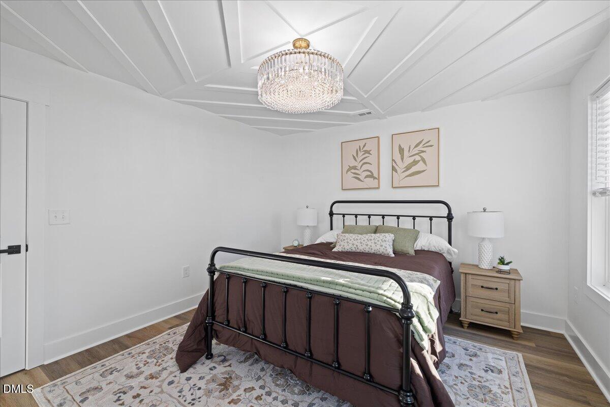 617 North 3rd Street Mebane, NC 27302 - Photo 28 of 50 a bedroom with a bed and a chandelier