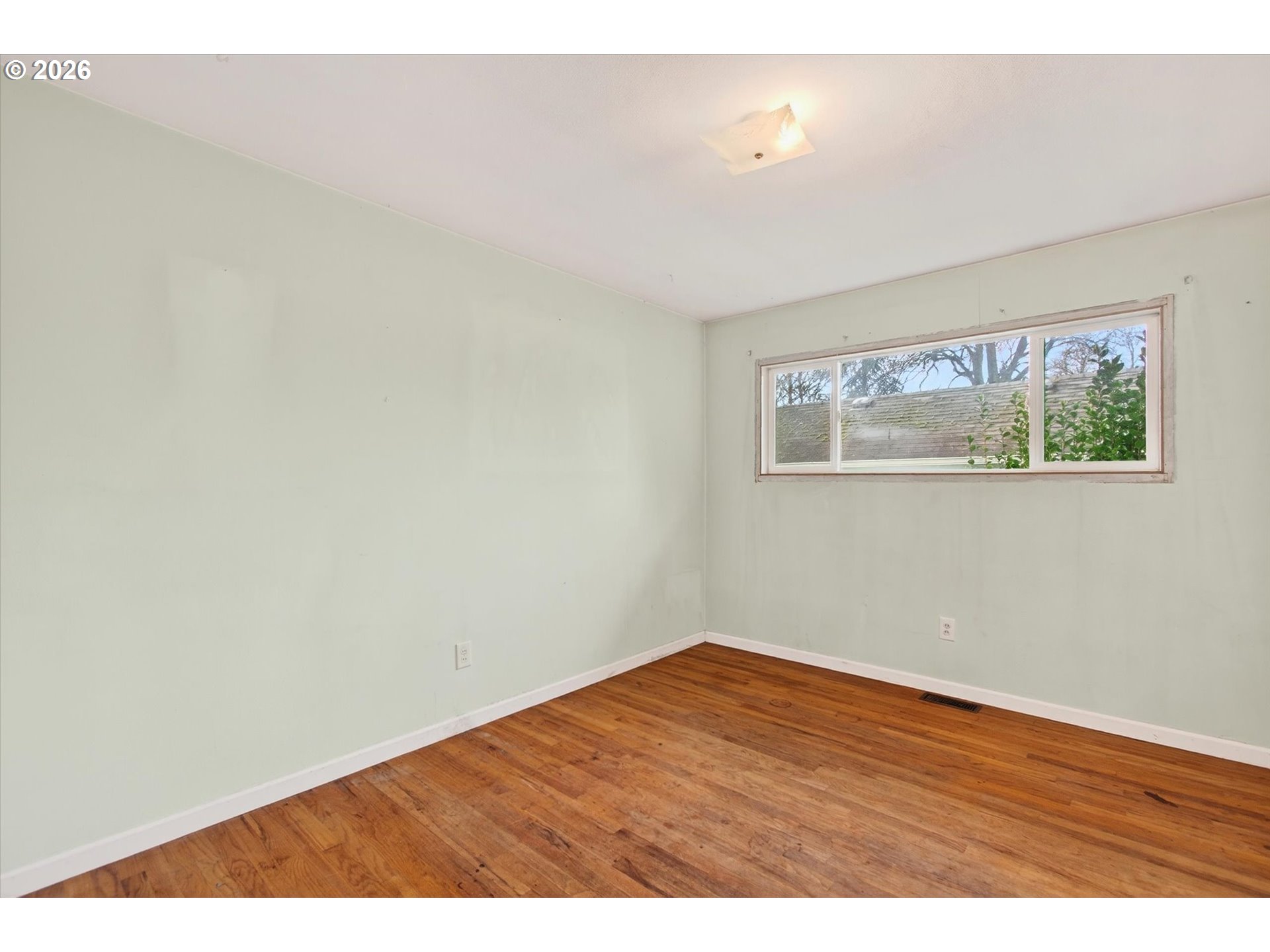 919 Cascade Drive Longview, WA 98632 - Photo 13 of 33 a view of an empty room with wooden floor and a window