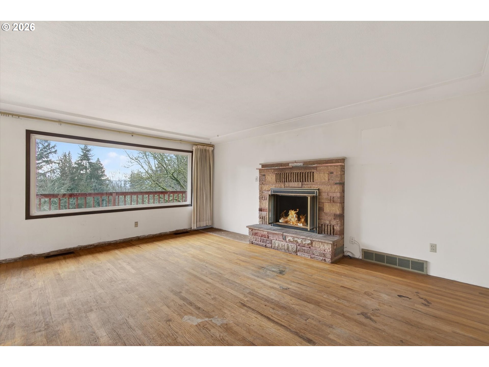 919 Cascade Drive Longview, WA 98632 - Photo 4 of 33 a view of an empty room with a fireplace and wooden floor