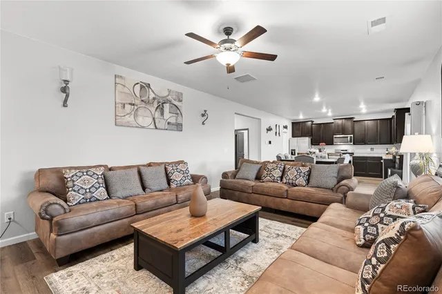 a living room with furniture kitchen view and a chandelier