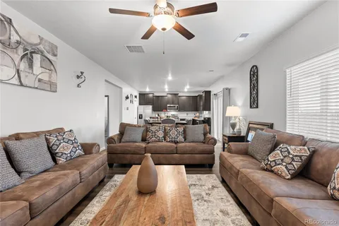 a living room with furniture and a ceiling fan