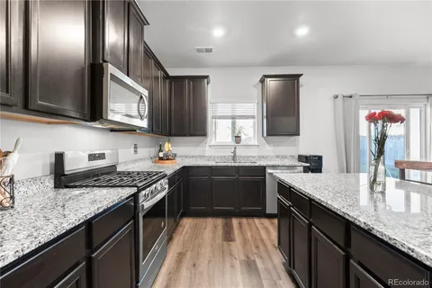 a kitchen with granite countertop stainless steel appliances and wooden cabinets