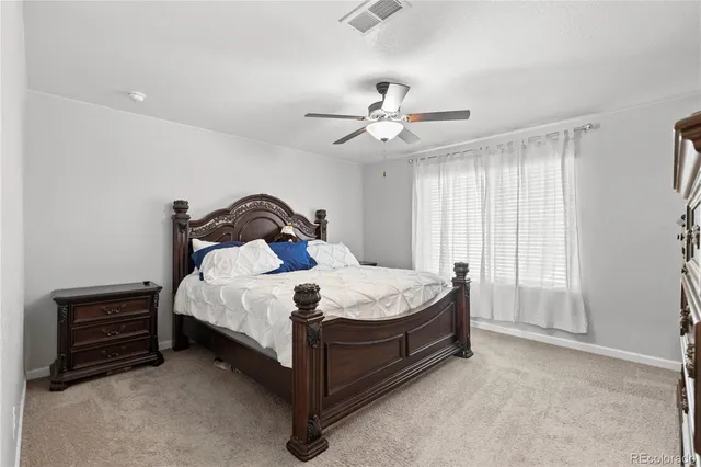 a bedroom with a bed and a ceiling fan