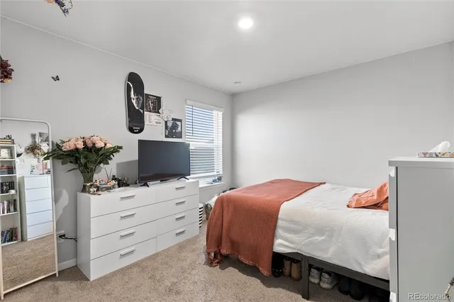 a bedroom with a bed and a potted plant