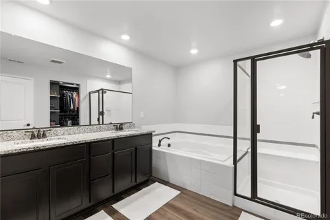 a bathroom with a double vanity sink a mirror and a bathtub