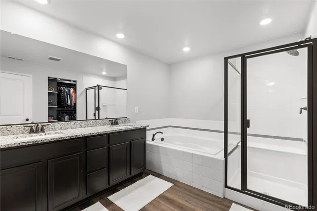 a bathroom with a double vanity sink a mirror and a bathtub