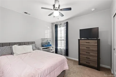 a bedroom with a bed and a flat tv screen on dresser