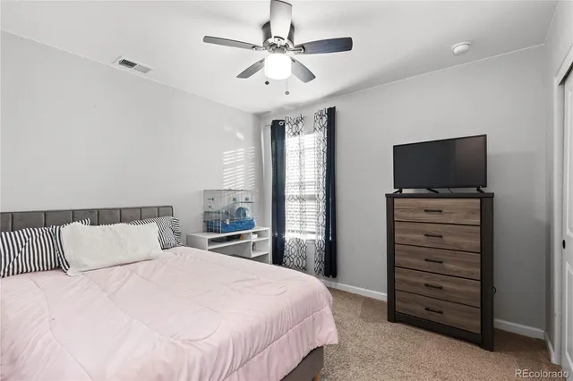 a bedroom with a bed and a flat tv screen on dresser