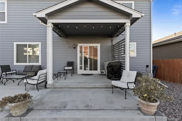 a view of a patio with couple of chairs and a potted plant