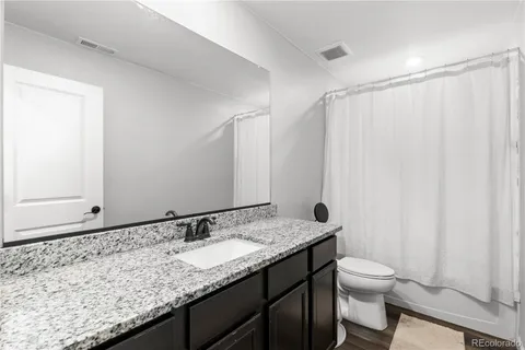 a bathroom with a granite countertop sink and a mirror