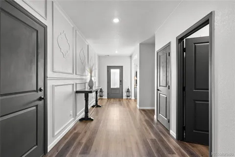 a view of a hallway with wooden floor and staircase
