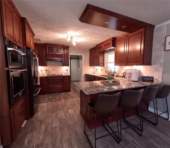 a kitchen with cabinets and wooden floor