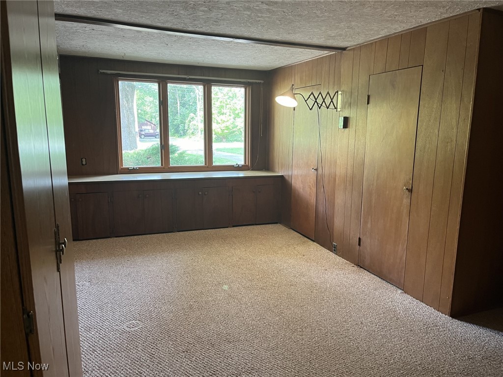 6735 Hathaway Road Cleveland, OH 44125 - Photo 28 of 44 Another view of the bonus room with window bench cabinet and wooden storage closets.