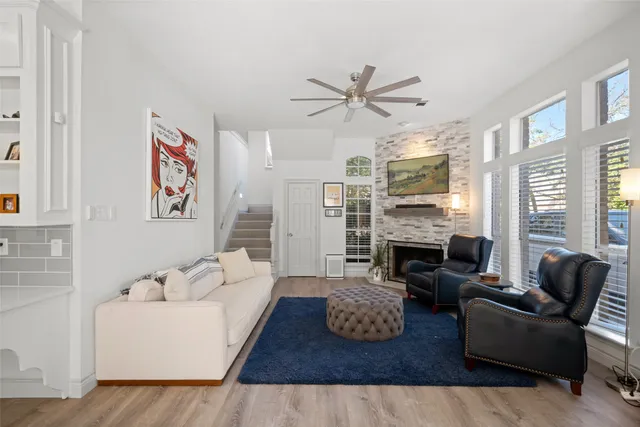 a living room with furniture fireplace and a large window
